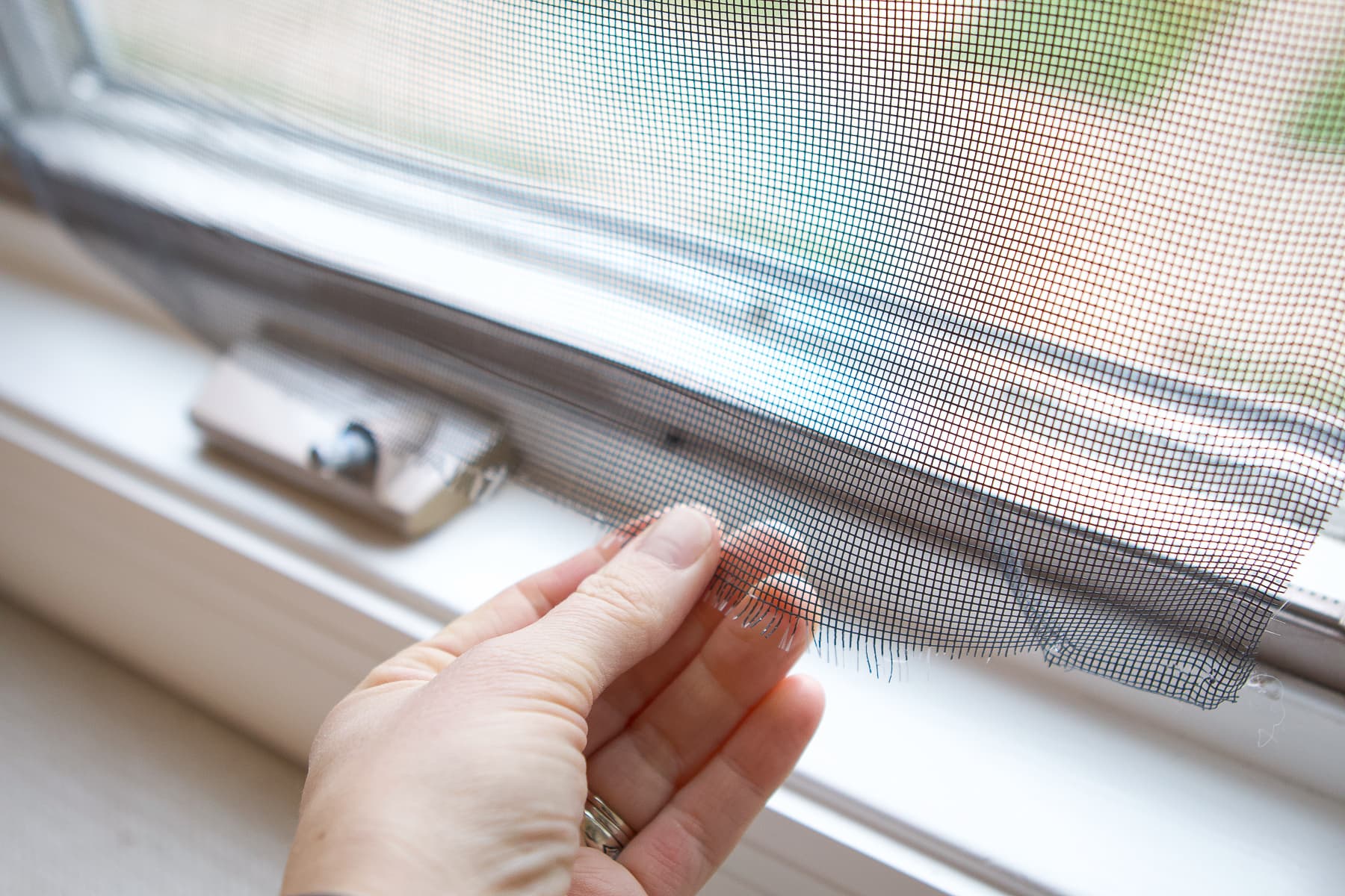 Experienced technician carefully patching damaged screen mesh with precise repair tools