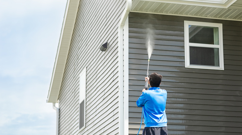 Residential siding being washed to remove algae streaks and heavy exterior buildup